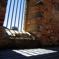 sun shining through the bars on the convict cell